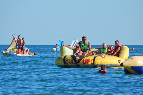 Persone si divertono su gonfiabili e pedalò al Camping Pra'delle Torri, parco vacanze in Veneto, Italia.