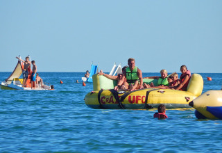 Persone si divertono su gonfiabili e pedalò al Camping Pra'delle Torri, parco vacanze in Veneto, Italia.