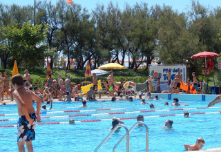 Folk hygger sig ved en udendørs swimmingpool på Camping Pra'delle Torri feriested i Veneto, Italien.