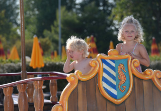 Due bambini giocano su un parco giochi con stemma a cavalluccio marino al Camping Pra'delle Torri, Veneto, Italia.