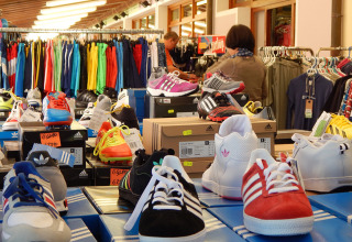 Des chaussures de sport et des vêtements colorés exposés dans une boutique au Camping Pra'delle Torri, Vénétie, Italie.
