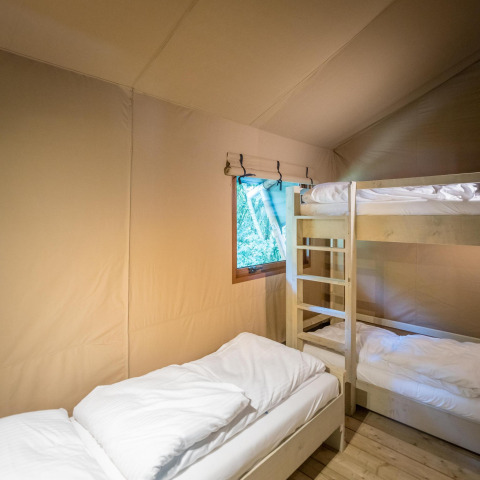 Indvendig udsigt af Family Glampingtent - IEPER med køjeseng og enkeltseng på Urban-Gardens Ieper, Belgien.