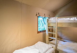 Vista interior de la Family Glampingtent - IEPER con litera y cama individual en Urban-Gardens Ieper, Bélgica.