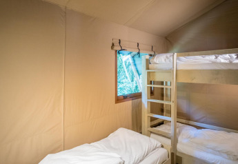 Binnenzicht van Family Glampingtent - IEPER met stapelbed en enkel bed bij Urban-Gardens Ieper, België.