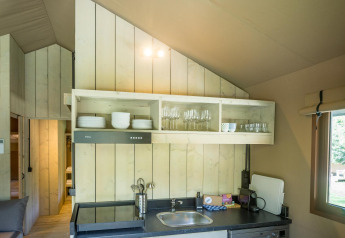 Kitchen area in the Family Glampingtent at Urban-Gardens Ieper, Belgium, featuring shelves and sink.
