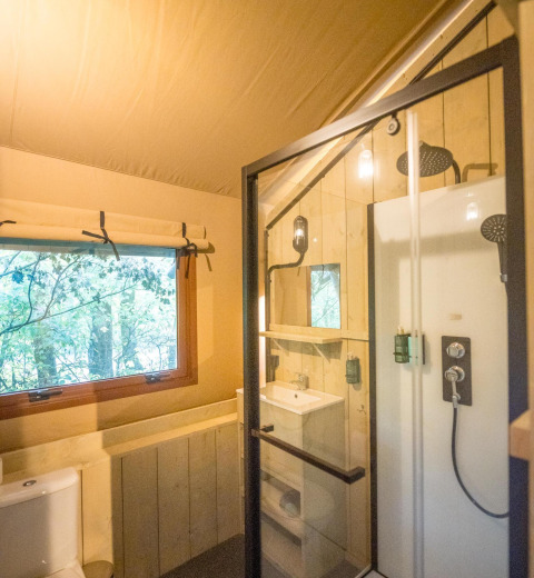 Baño en tienda safari con ducha y ventana en Family Glampingtent - IEPER, Urban-Gardens Ieper, Bélgica.