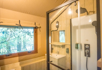 Baño en tienda safari con ducha y ventana en Family Glampingtent - IEPER, Urban-Gardens Ieper, Bélgica.