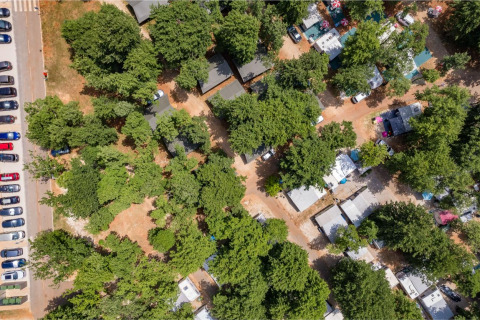Vista aérea de Camping Park Umag en Istria, Croacia, con árboles, cabañas, casas rodantes y coches aparcados.