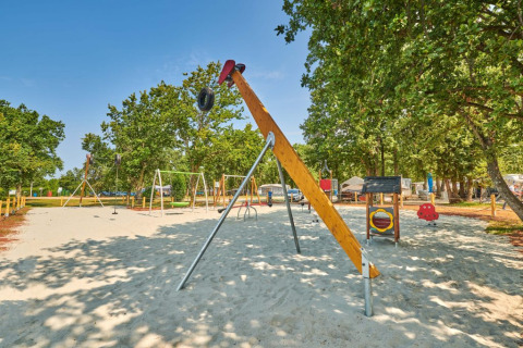 Parco giochi con altalene e attrezzi al Camping Park Umag, Istria, Croazia, in una giornata di sole.