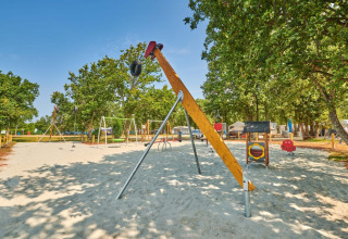 Legeplads med gynger, rutschebane og legeredskaber i Camping Park Umag, Istrien, Kroatien på en solrig dag.
