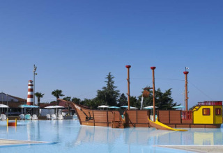 Schwimmbad im Camping Park Umag, Kroatien, mit Piratenschiff-Spielplatz und Leuchtturm im Hintergrund.