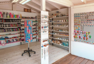 Butik på Camping Park Umag i Kroatien med souvenirs, magneter, armbånd og lokale produkter på hylder.