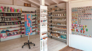 Tienda de regalos en Camping Park Umag, Croacia, con imanes, pulseras y recuerdos típicos en estantes.