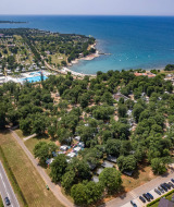 Vista aérea de Camping Park Umag en Istria, Croacia, con zonas de acampada, piscina y costa al mar.