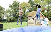 Deux enfants sautent et jouent sur un grand coussin gonflable à The HappyFarm, parc de vacances en Gueldre, Pays-Bas.