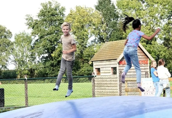 Deux enfants sautent et jouent sur un grand coussin gonflable à The HappyFarm, parc de vacances en Gueldre, Pays-Bas.