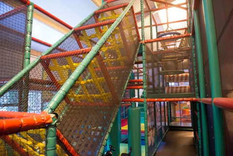 Indoor speeltoestel met klimstructuren en netten in vakantiepark The HappyFarm, Gelderland, Nederland.