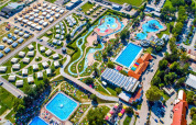 Luftfoto af Camping Terme Čatež-ferieparken med pools, vandrutsjebaner og campinghytter i Slovenien.