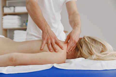 Un homme fait un massage relaxant du dos à une femme sur une table de massage au Camping Terme Catez, Slovénie.