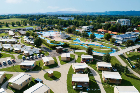 Vista aerea di Camping Terme Čatež in Slovenia con bungalow, piscine, aree verdi e scivoli d’acqua.