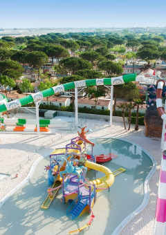 Vista aérea de Camping Union Lido Mare en Véneto, Italia, con toboganes de agua coloridos y piscinas en el parque.