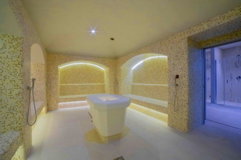 Sala de spa moderna con baño de vapor y banco de mármol en Camping Village Cavallino, Véneto, Italia.