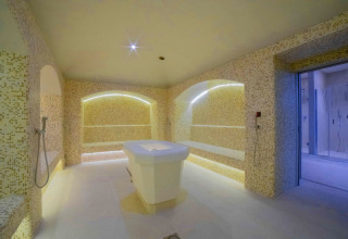 Stanza benessere moderna con bagno turco e panca in marmo al Camping Village Cavallino, Veneto, Italia.