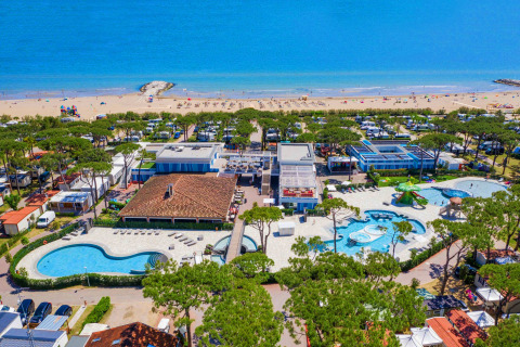 Vista aérea de Camping Village Cavallino en Véneto, Italia, con piscinas, playa y cabañas de vacaciones.