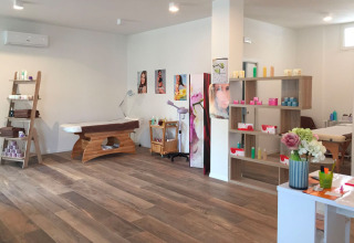 Moderne wellness- og behandlingsrum med massageborde, hylder med produkter og trægulv i Cavallino.