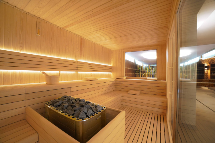 Moderne sauna met houten banken en saunakachel in Camping Village Cavallino, Veneto, Italië.