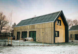 Modern tiny house Unbrick One with wood exterior and sauna at Brinckerduyn, Netherlands in winter.