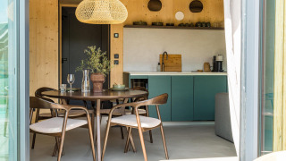 Modernes Tiny House Küche und Essbereich im Unbrick One mit natürlichen Holzelementen und stilvollem Design.