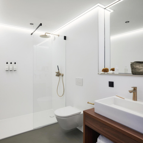 Modern bathroom in Unbrick One, Netherlands, featuring a walk-in shower, wall toilet, and minimalist design.