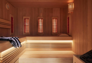 Vista interior de una sauna moderna con bancos de madera e iluminación cálida en Unbrick One tiny house, Brinckerduyn.