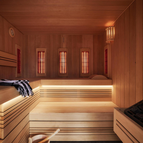 Vista interior de una sauna moderna con bancos de madera e iluminación cálida en Unbrick One tiny house, Brinckerduyn.