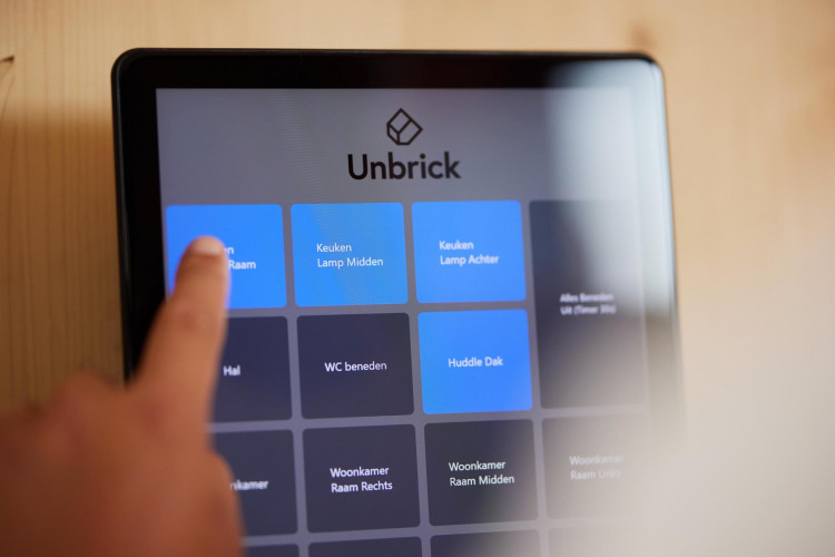 Dedo toca pantalla de control inteligente Unbrick en una Tiny House en Brinckerduyn, Países Bajos.