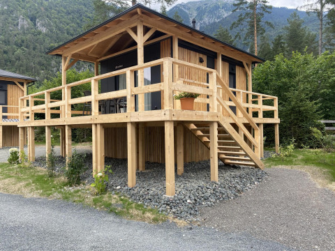 Wooden lodge Edelweiss at Ossiacher See, Austria, featuring a large deck and surrounded by mountains.