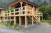 Houten lodge Edelweiss aan Ossiacher See in Oostenrijk, met ruim terras en uitzicht op bergen.