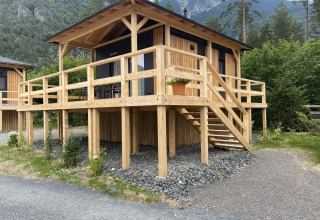 Wooden lodge Edelweiss at Ossiacher See, Austria, featuring a large deck and surrounded by mountains.