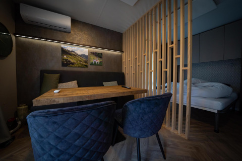 Interior moderno de lodge en Edelweiss en Ossiacher See, Austria, con mesa de comedor y cama visible.