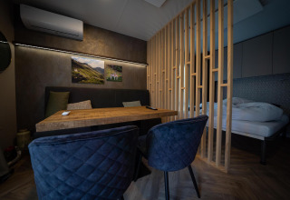 Intérieur moderne d'un lodge à Edelweiss, Ossiacher See, Autriche, avec table à manger et coin lit.