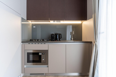 Contemporary kitchenette at Edelweiss Lodge with stove, microwave, coffee maker, and electric kettle.