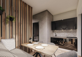 Moderno lodge all’Ossiacher See, Austria, con arredo in legno chiaro, angolo cucina e zona pranzo accogliente.