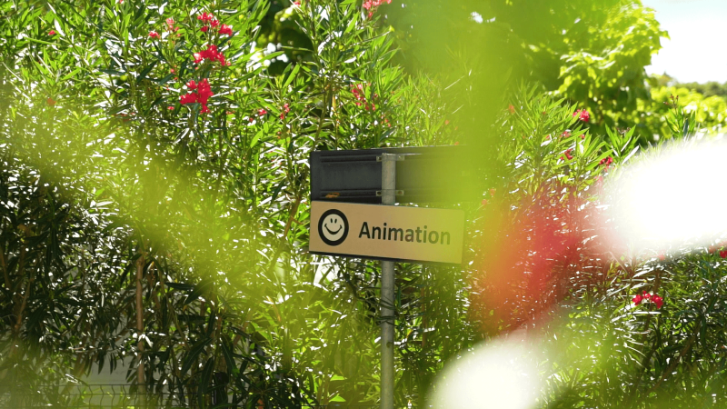 Sign at Camping Zelena Laguna, Istria, Croatia, pointing to the animation area surrounded by greenery.