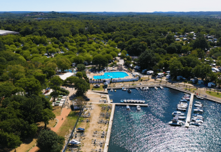 Luftfoto af Camping Zelena Laguna i Istrien, Kroatien, med swimmingpool, campingvogne og marina.