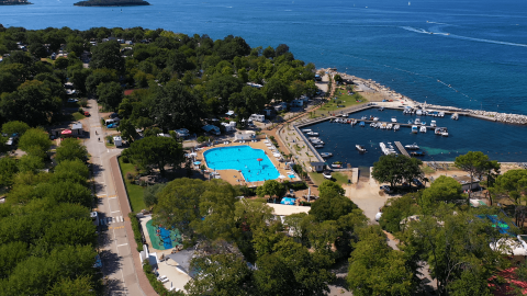 Vista aerea del Camping Zelena Laguna in Istria, Croazia, con piscina, porto turistico e il mare sullo sfondo.