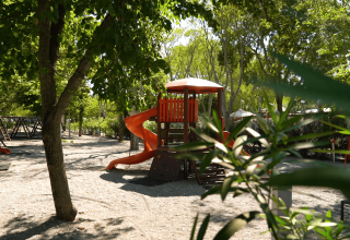 Parco giochi per bambini con scivoli all’ombra degli alberi presso il Camping Zelena Laguna, Istria.