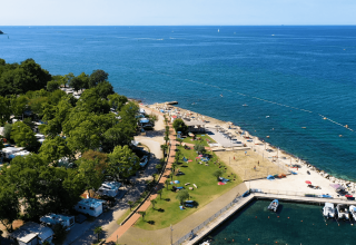 Vista aerea del Camping Zelena Laguna in Istria, Croazia, con roulotte, spiaggia, prato verde e mare Adriatico.