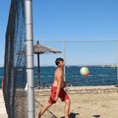 Niño jugando voleibol en la playa del Camping Zelena Laguna, Istria, Croacia, junto al mar.