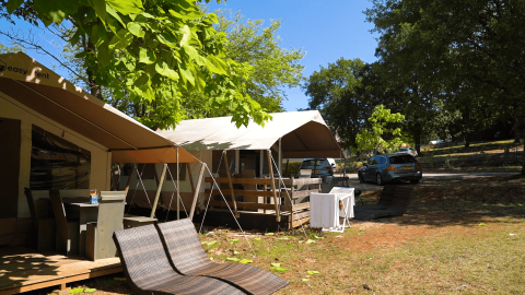 Camping Zelena Laguna in Istria, Croazia, mostra tende, area relax esterna e auto parcheggiate all’ombra.